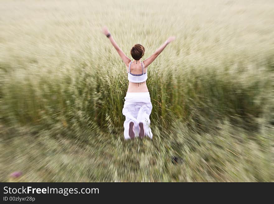 Young blond woman jumping in meadow.