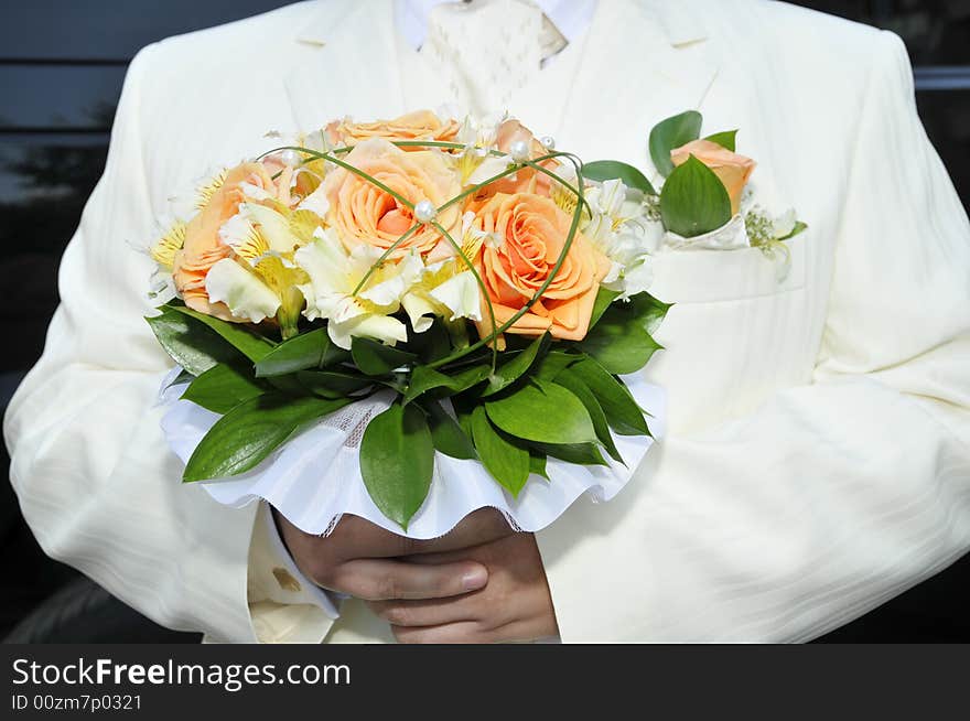 Groom in luxurious wedding suit with wedding bouquet. Groom in luxurious wedding suit with wedding bouquet