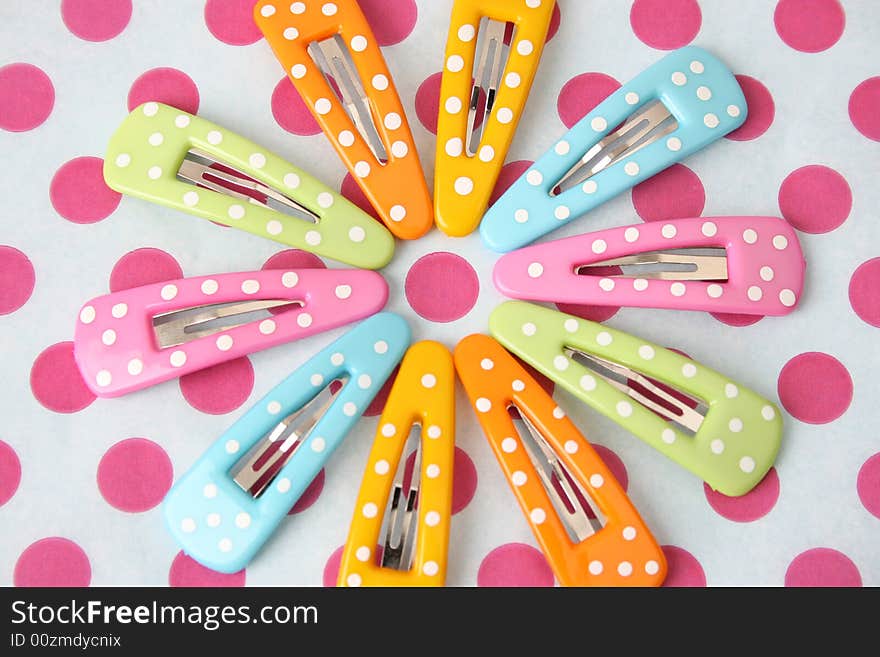 Brightly colored polka dot hair accessories on a polka dot background