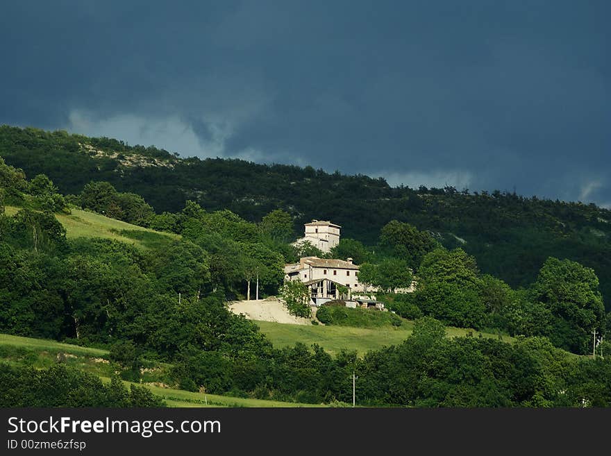 Lonely farm at the hill just before the storm