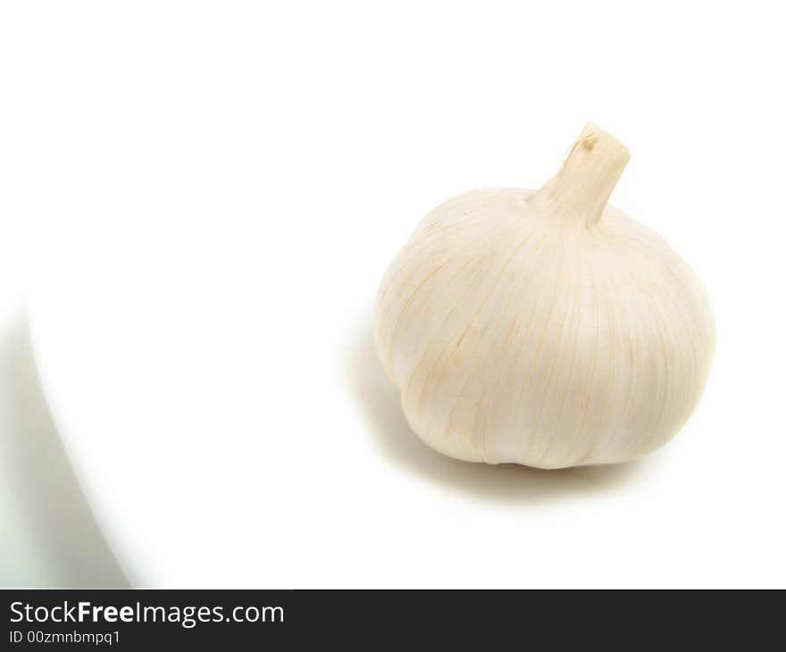 A bulb of garlic on white plate and isolated on white background