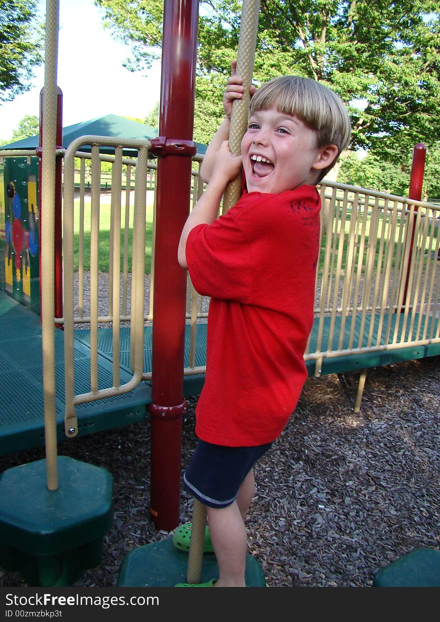 A young boy laughs at the playground. A young boy laughs at the playground