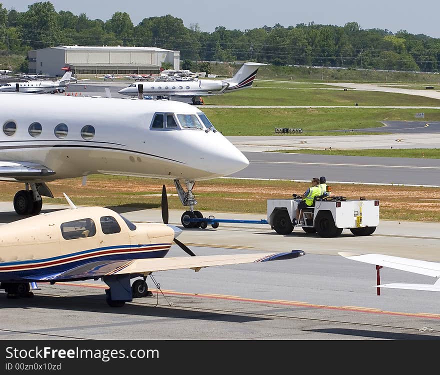 A towing vehicle pulling a jet off the runway. A towing vehicle pulling a jet off the runway