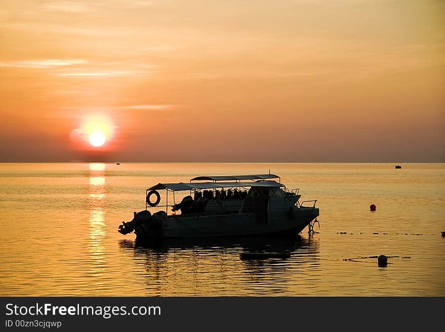 Golden sunset creating a stilling silhouette of 2 speedboats on a very calm sea. Golden sunset creating a stilling silhouette of 2 speedboats on a very calm sea