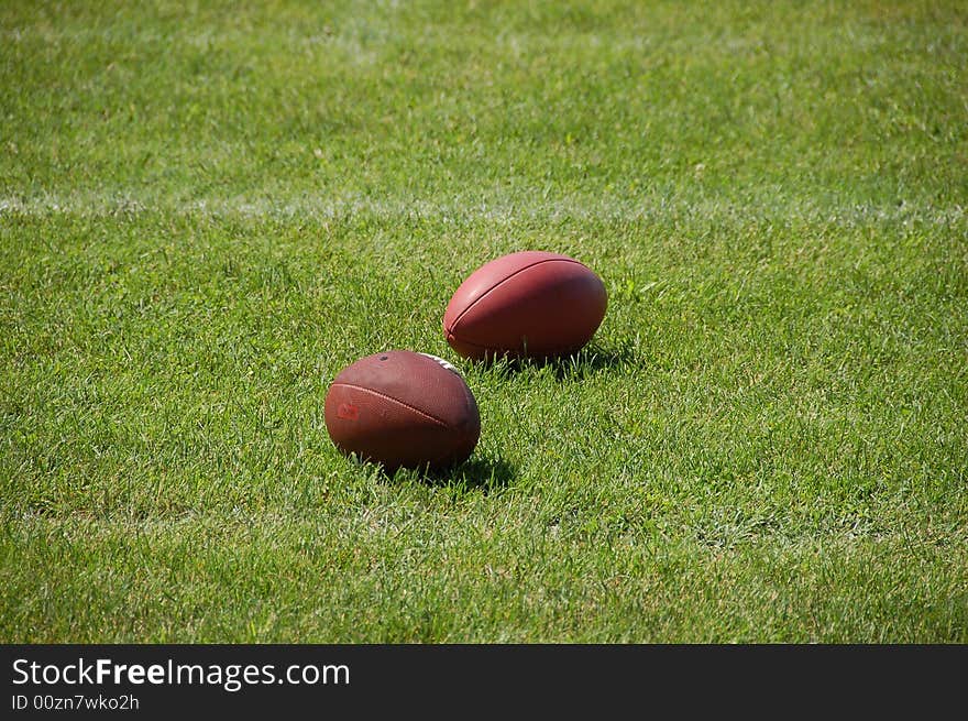 Two American Football balls on the grass. Two American Football balls on the grass