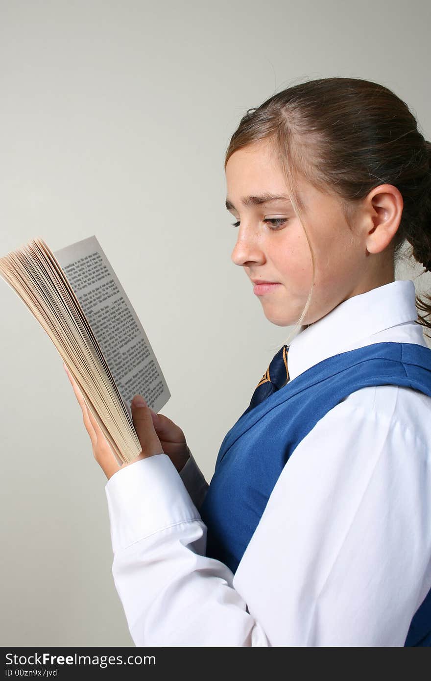 Teenage School girl reading a book, wearing uniform