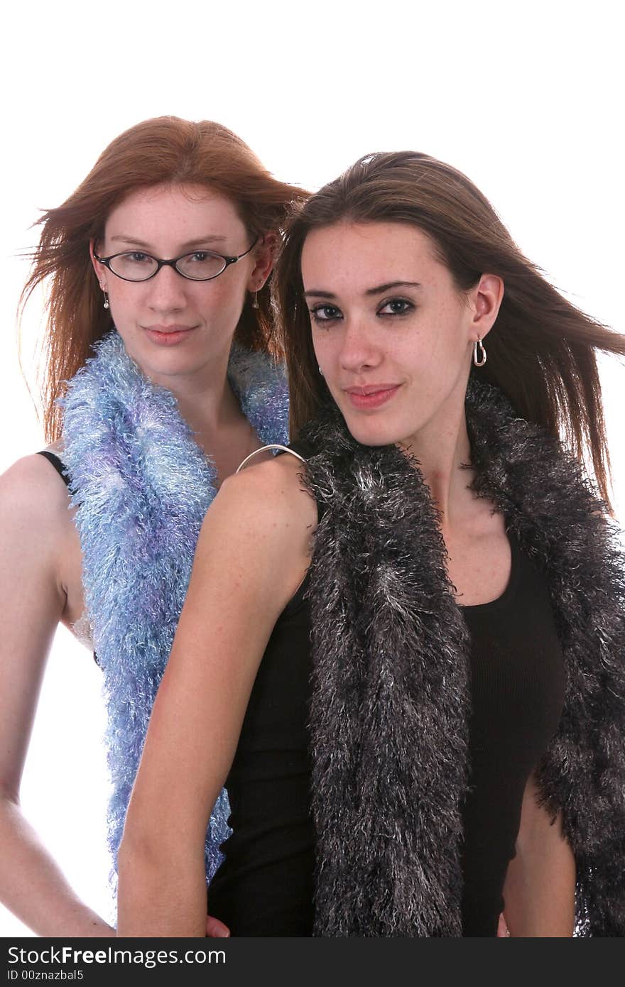 Two beautiful teenage girls with windblown hair and fluffy scarfs