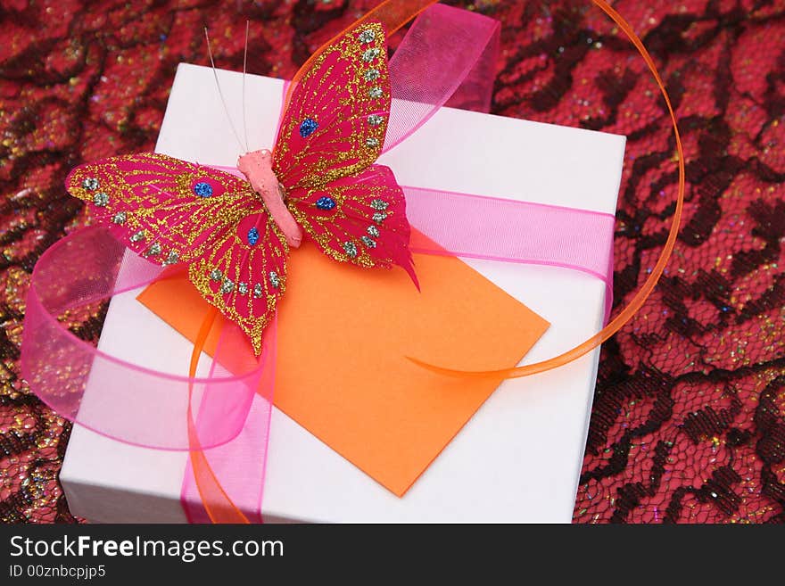 Pink butterfly on a white gift box as a decoration. Pink butterfly on a white gift box as a decoration