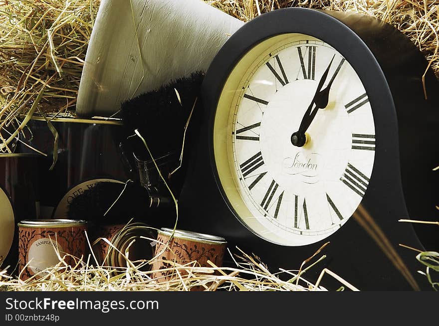 Clock and paint tins with straw