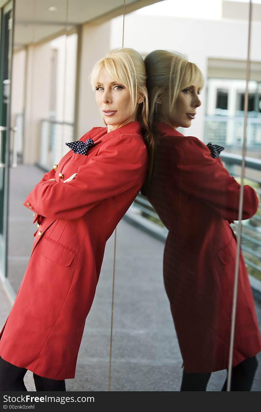 Blonde Businesswoman leaning against a reflective surface. Blonde Businesswoman leaning against a reflective surface