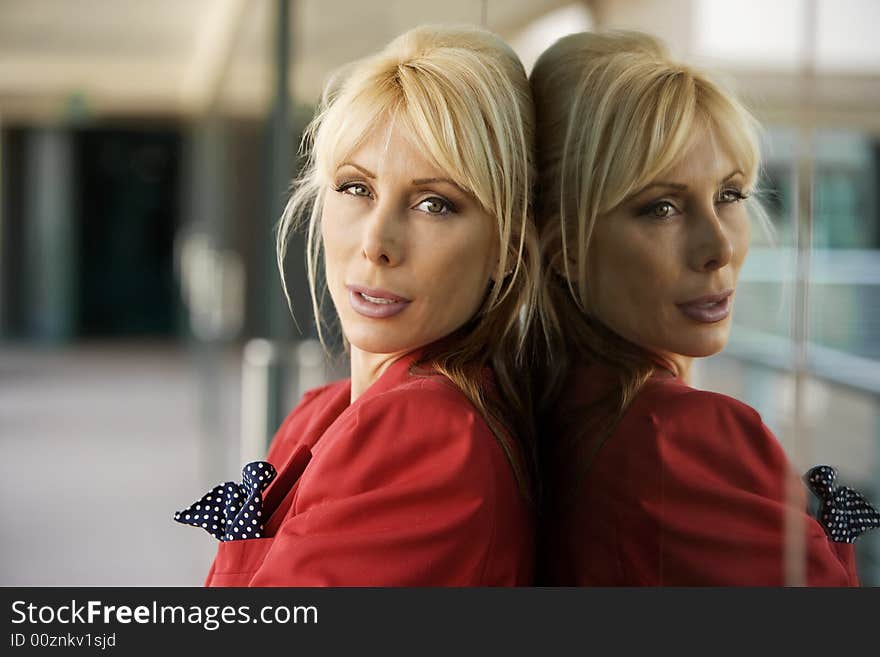 Blonde Businesswoman leaning against a reflective surface. Blonde Businesswoman leaning against a reflective surface