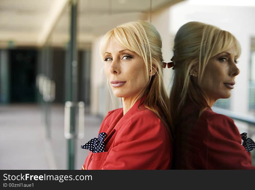 Blonde Businesswoman leaning against a reflective surface. Blonde Businesswoman leaning against a reflective surface