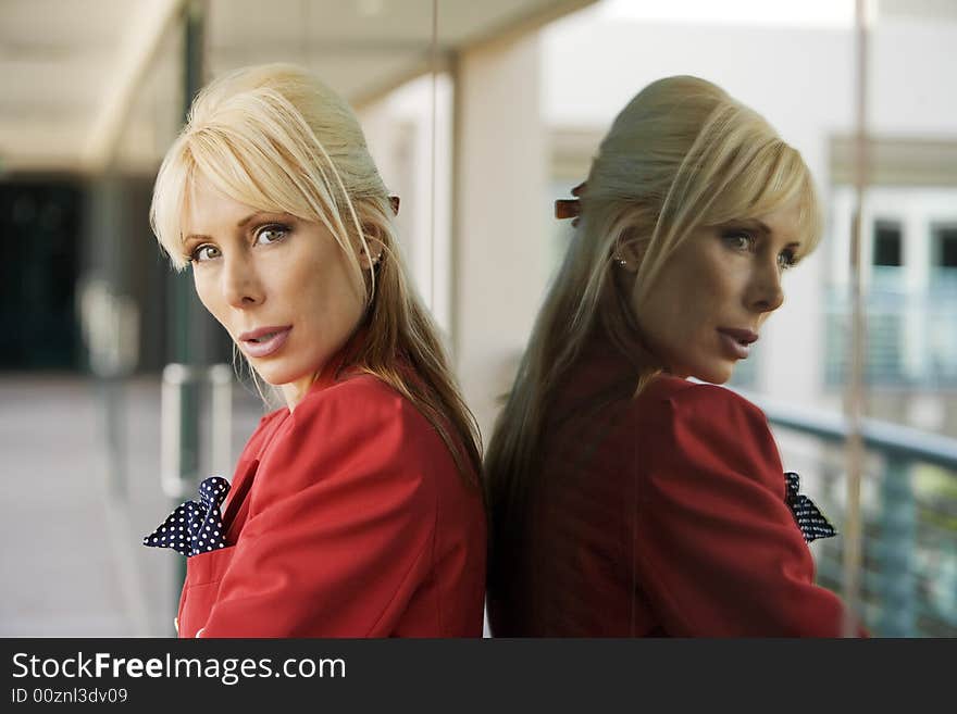 Blonde Businesswoman leaning against a reflective surface. Blonde Businesswoman leaning against a reflective surface