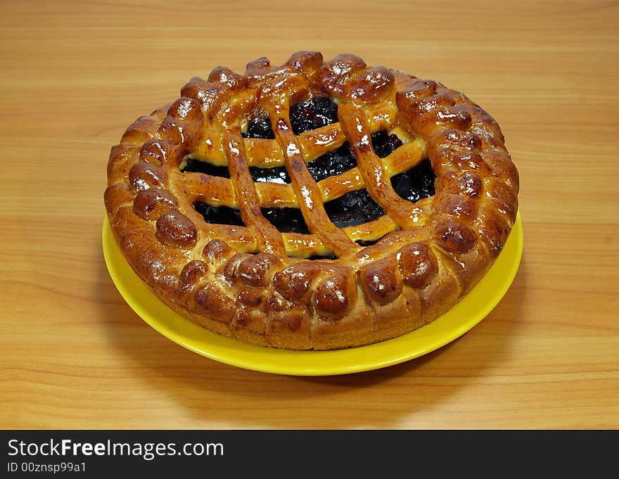 Fresh sweet pie with bilberry on a yellow plate