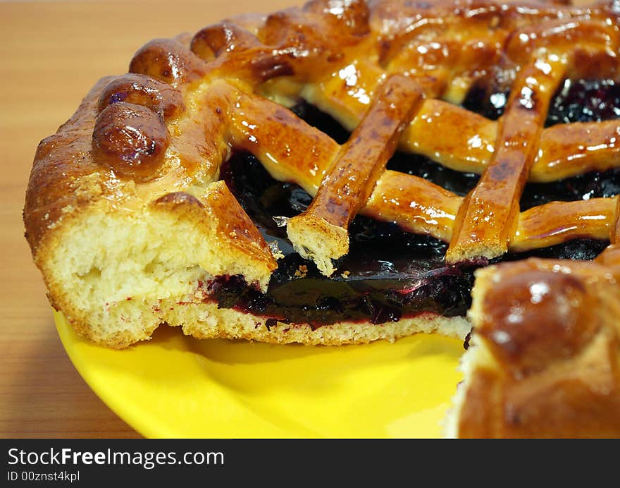 Fresh sweet pie with bilberry on a yellow plate. Fresh sweet pie with bilberry on a yellow plate