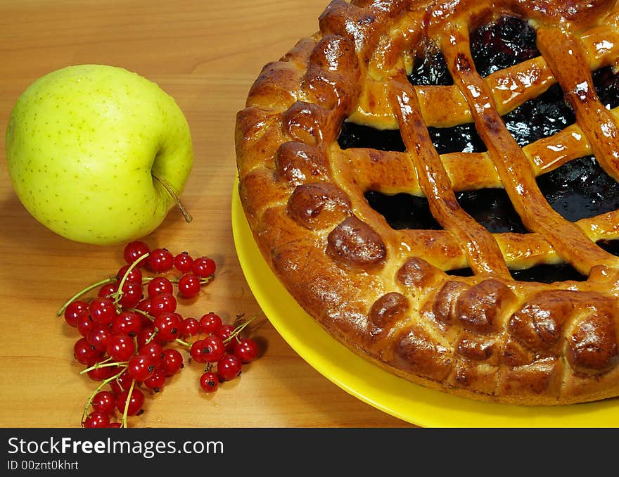 Fresh sweet pie with bilberry on a yellow plate. Fresh sweet pie with bilberry on a yellow plate