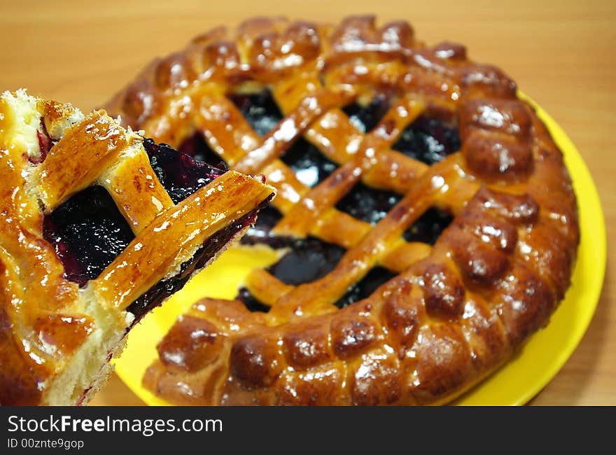 Fresh sweet pie with bilberry on a yellow plate. Fresh sweet pie with bilberry on a yellow plate