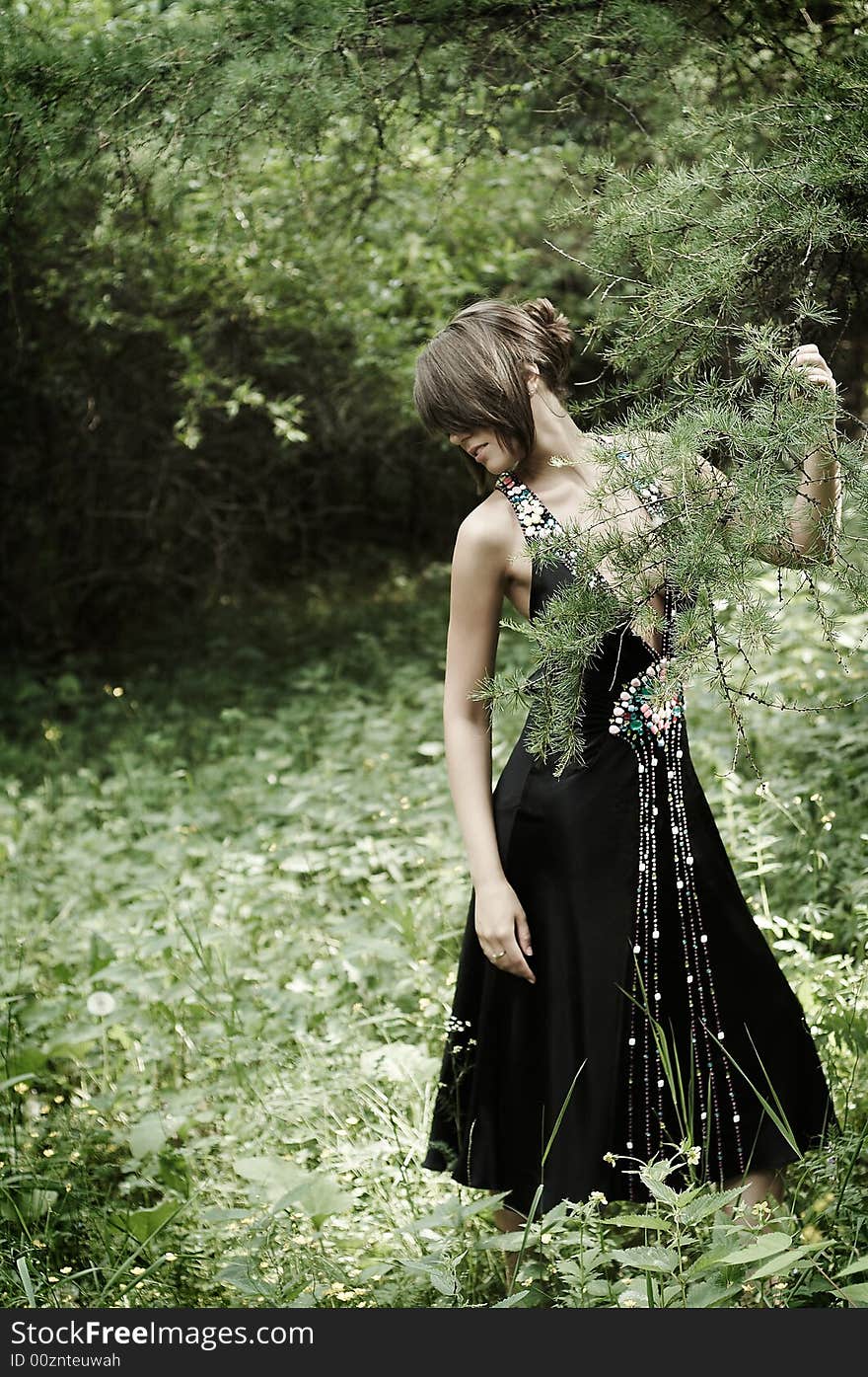 Beauty girl in black dress in the woods