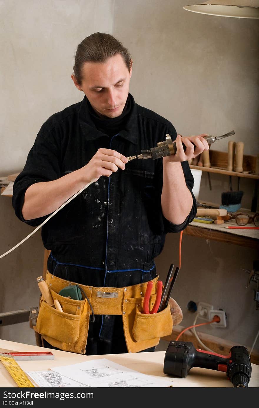 Carpenter prepare pneumatic chisel  in his workshop