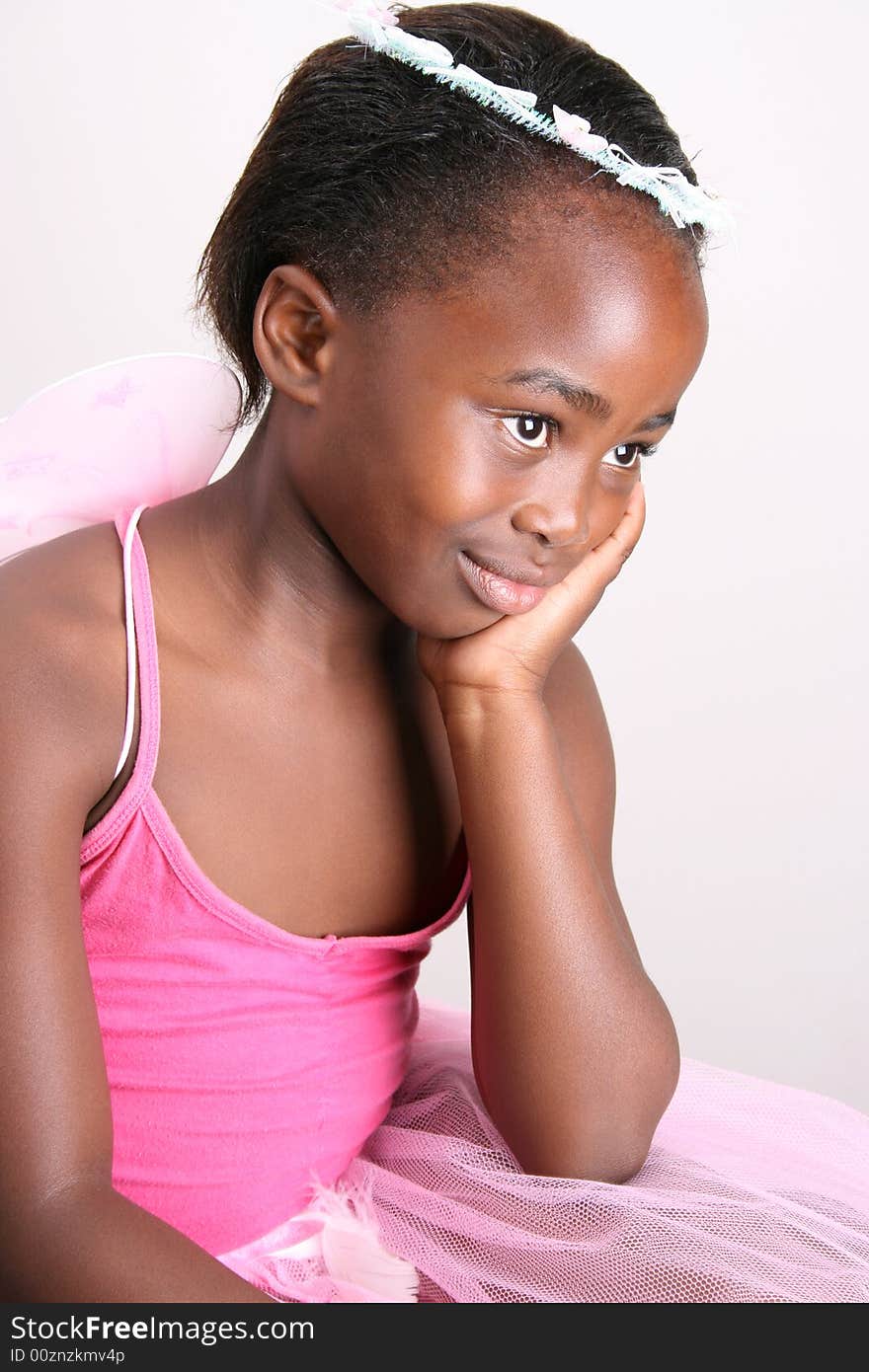 Young girl wearing a pink fairy costume with accessories