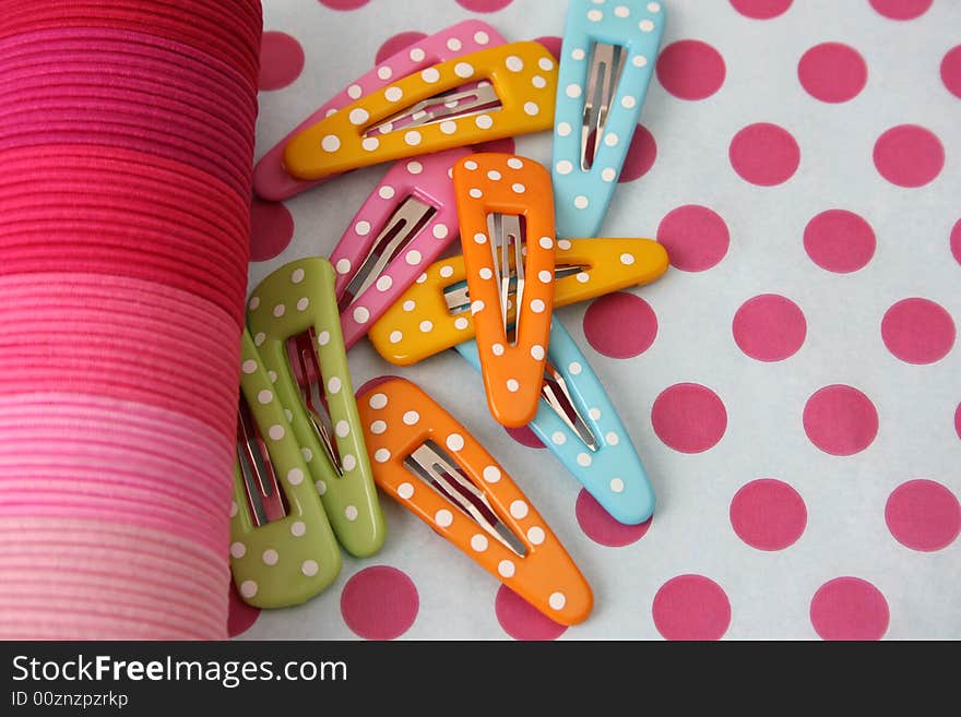 Brightly colored polka dot hair accessories on a polka dot background