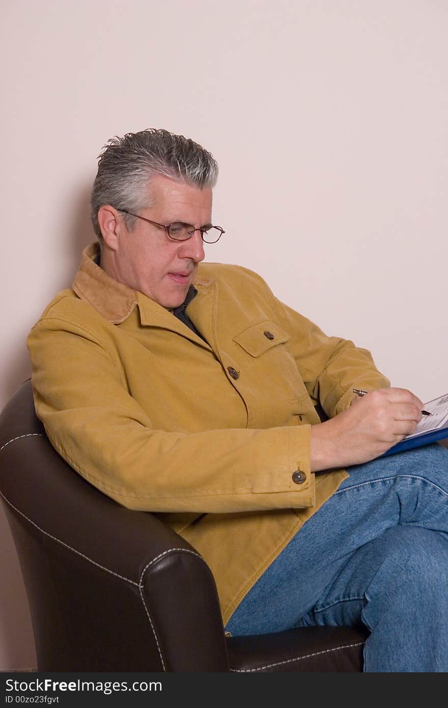 A business man writing a report in while in his study