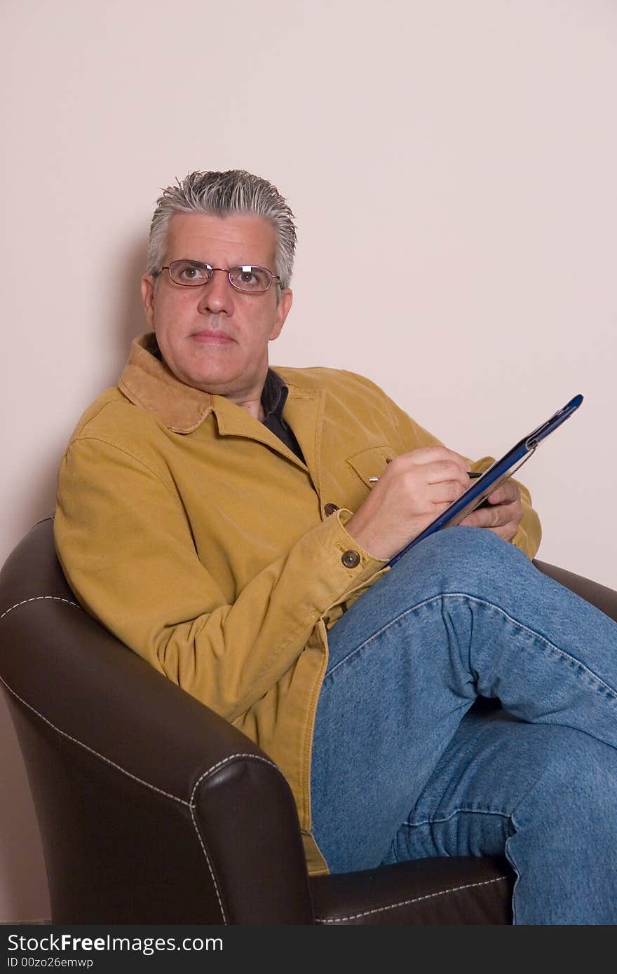 A business man writing a report in while in his study