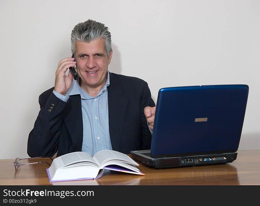 A businessman working in his study with a computer. A businessman working in his study with a computer