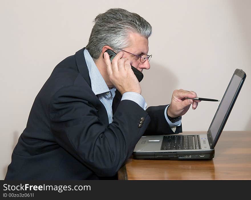 A businessman working in his study with a computer. A businessman working in his study with a computer