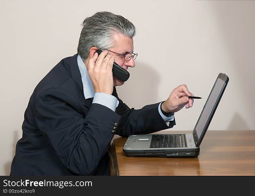 A businessman working in his study with a computer. A businessman working in his study with a computer