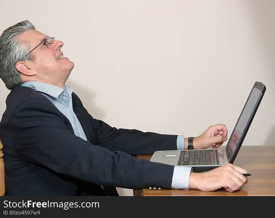 A businessman working in his study with a computer. A businessman working in his study with a computer