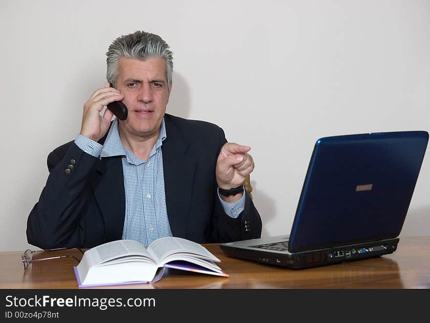 A businessman working in his study with a computer. A businessman working in his study with a computer