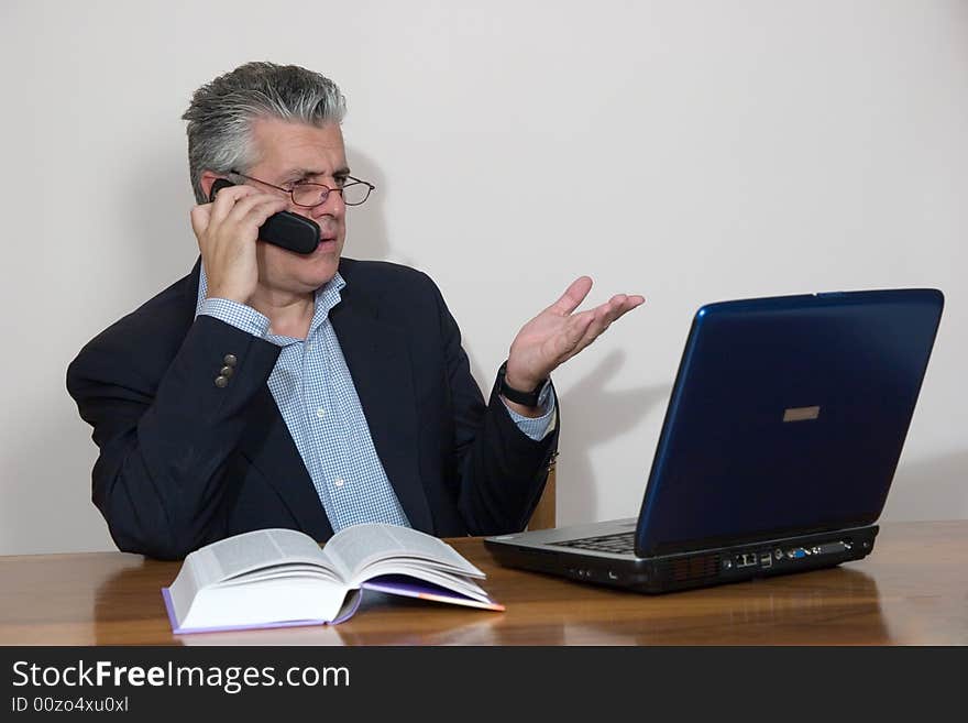 A businessman working in his study with a computer. A businessman working in his study with a computer