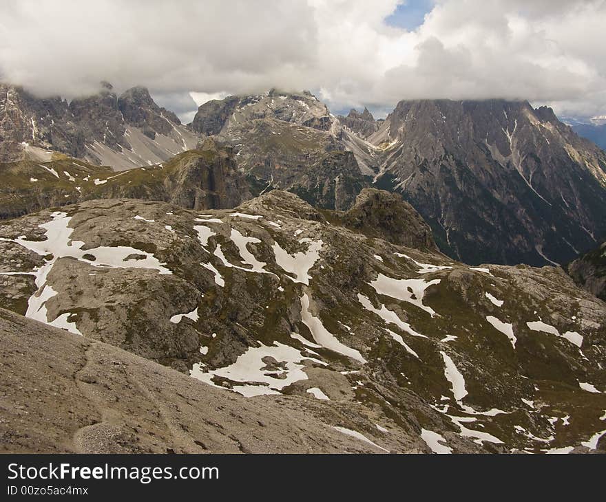 View of the area of Tre Cimes in Italy, dolomites, showing straight line of clouds covering the peaks. View of the area of Tre Cimes in Italy, dolomites, showing straight line of clouds covering the peaks.