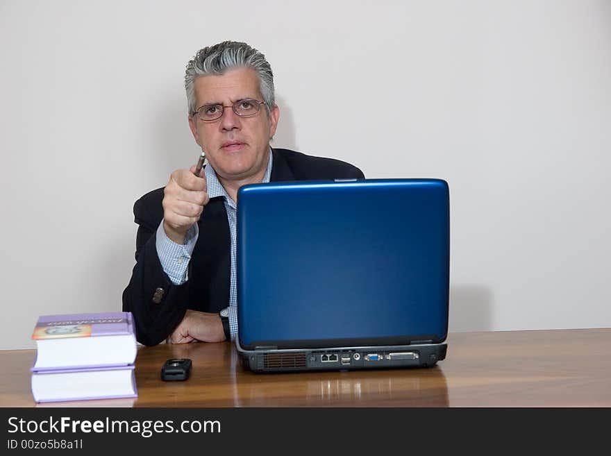 A businessman working in his study with a computer. A businessman working in his study with a computer