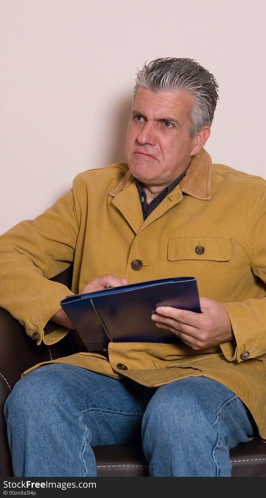 A businessman while writing a report in his study in a very concentrated way. A businessman while writing a report in his study in a very concentrated way