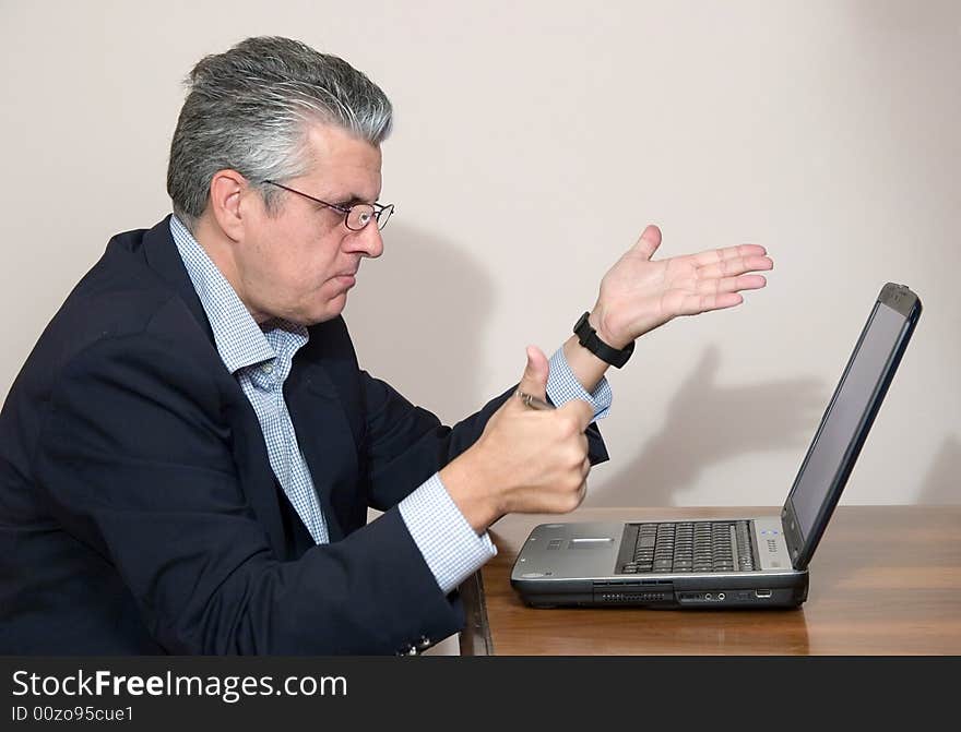 A businessman while writing a report in his study in a very concentrated way with a computer. A businessman while writing a report in his study in a very concentrated way with a computer