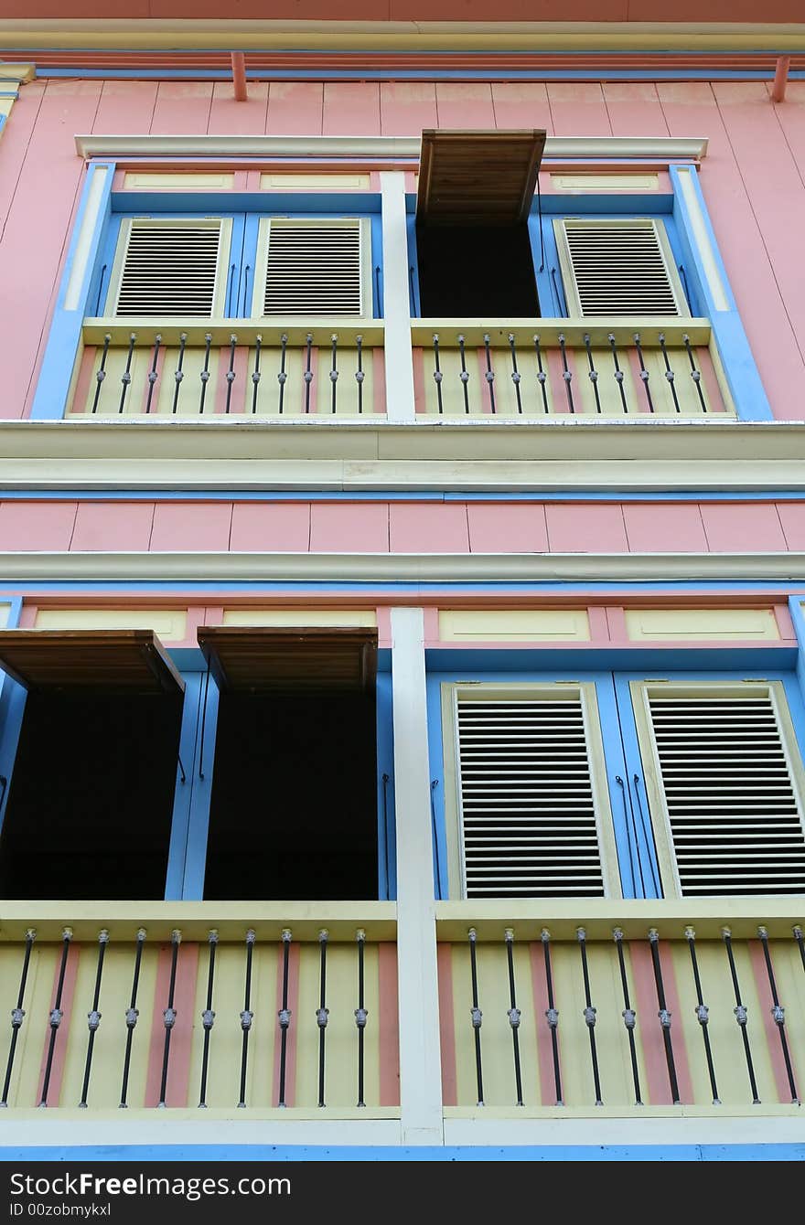 A colorful house with some of the shutters opened. A colorful house with some of the shutters opened