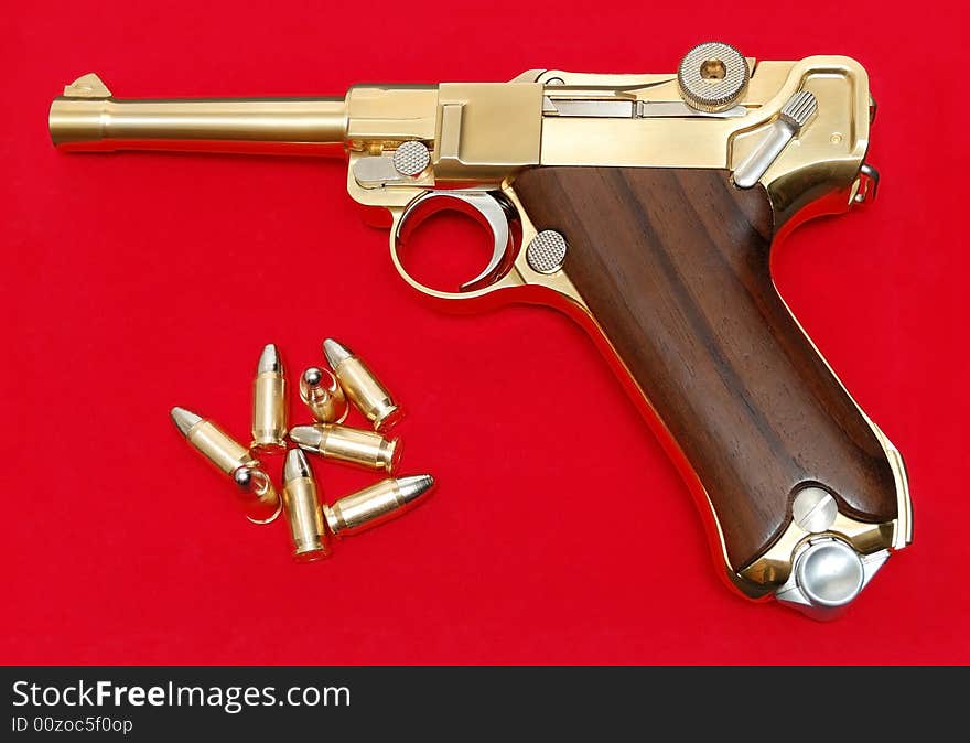 Golden gun isolated over a red background