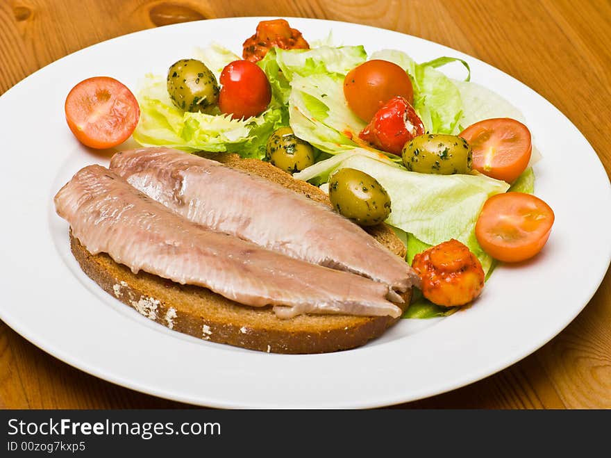 Herring and salad on a plate.