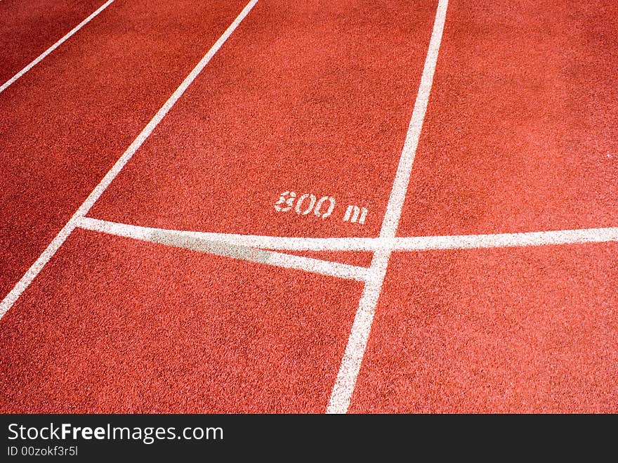 Red plastic raceway with white line in a sunny day.