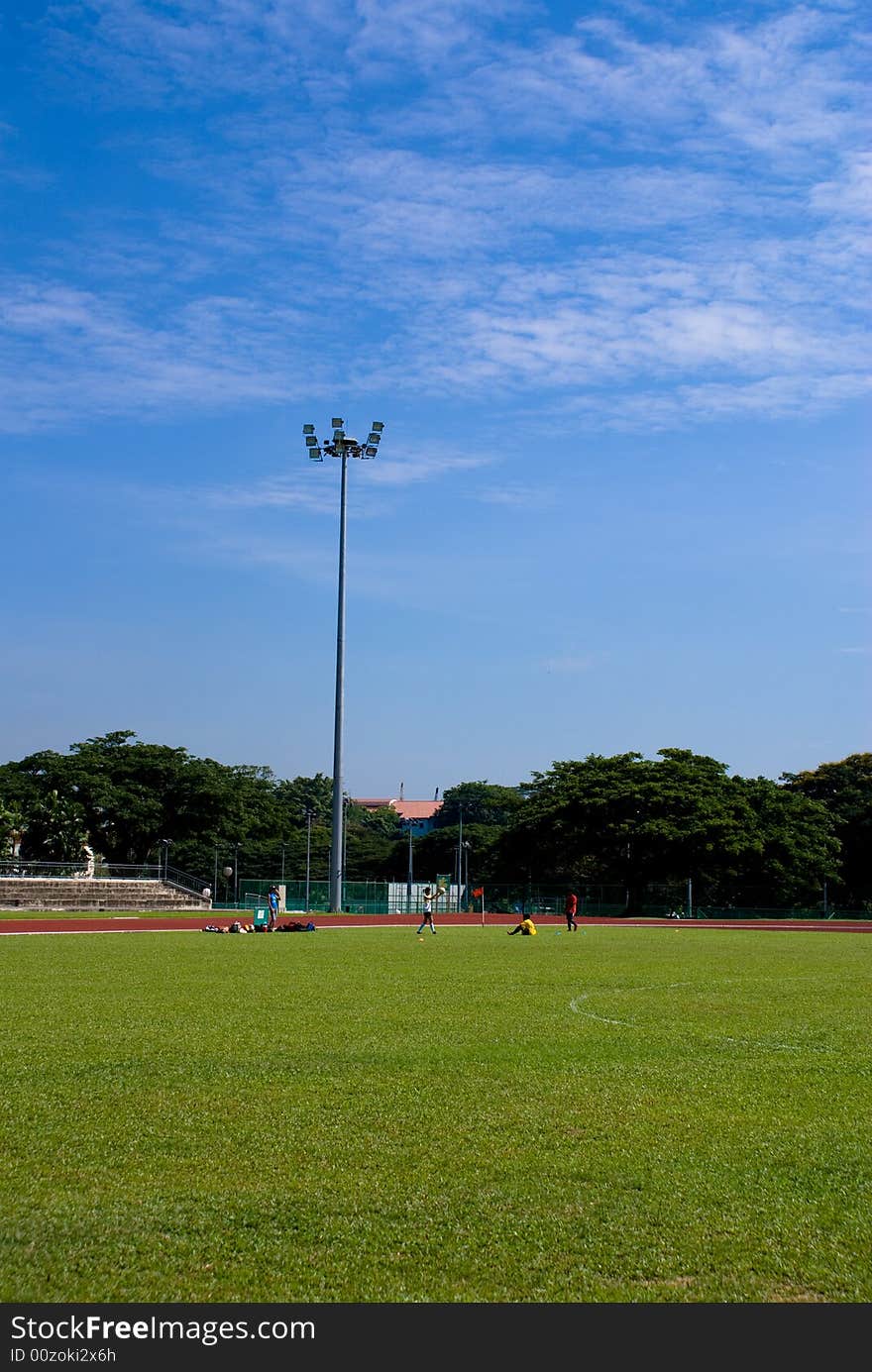 The refreshing campus scene in a university, the football field, the green grass, the floodlights, and the blue sky!. The refreshing campus scene in a university, the football field, the green grass, the floodlights, and the blue sky!