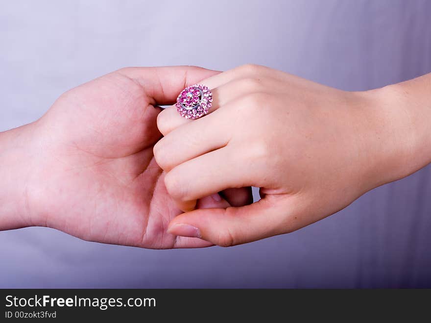 Hand in hand with a big purple diamond ring.