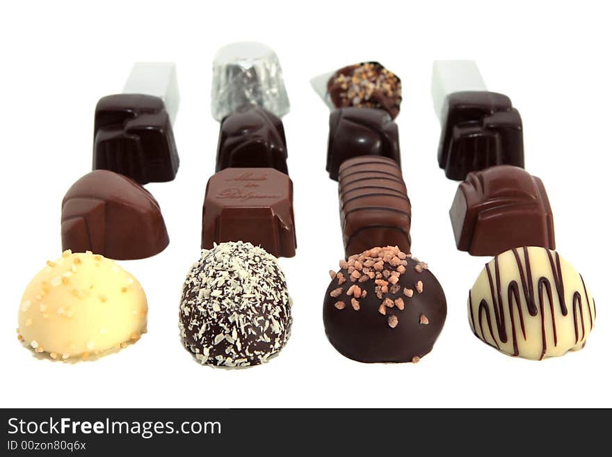 Sixteen luxury chocolates in rows on white background. Sixteen luxury chocolates in rows on white background