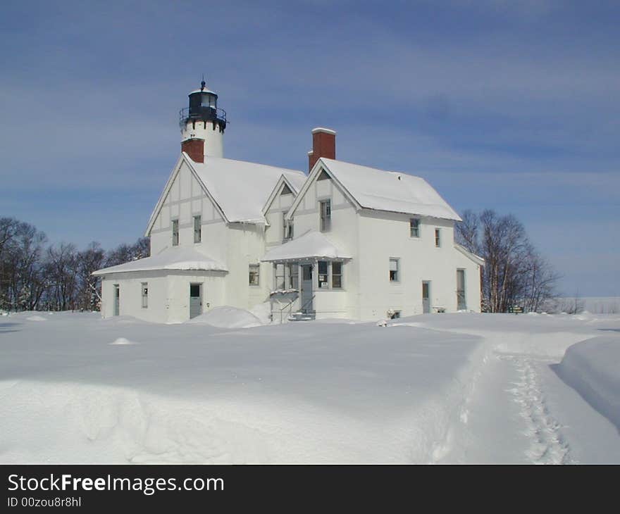 A guiding light from 1857 to 1962 stands frozen amidst the snowy tundra of upper Michigan in the dead of winter.  One lonesome set of foot prints leads up a path to the nostalgic motionless site. A guiding light from 1857 to 1962 stands frozen amidst the snowy tundra of upper Michigan in the dead of winter.  One lonesome set of foot prints leads up a path to the nostalgic motionless site.