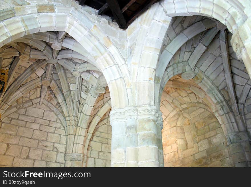 Ceilings with ribs, like a palm trees, arches, columns inside of cathedral in Santillana del Mar