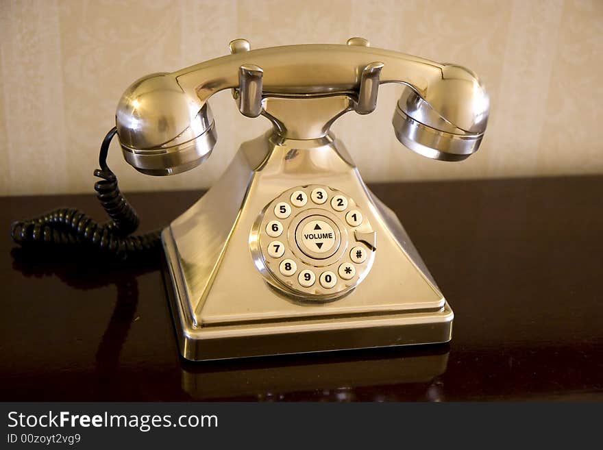 An old rotary phone in a gold finish. An old rotary phone in a gold finish