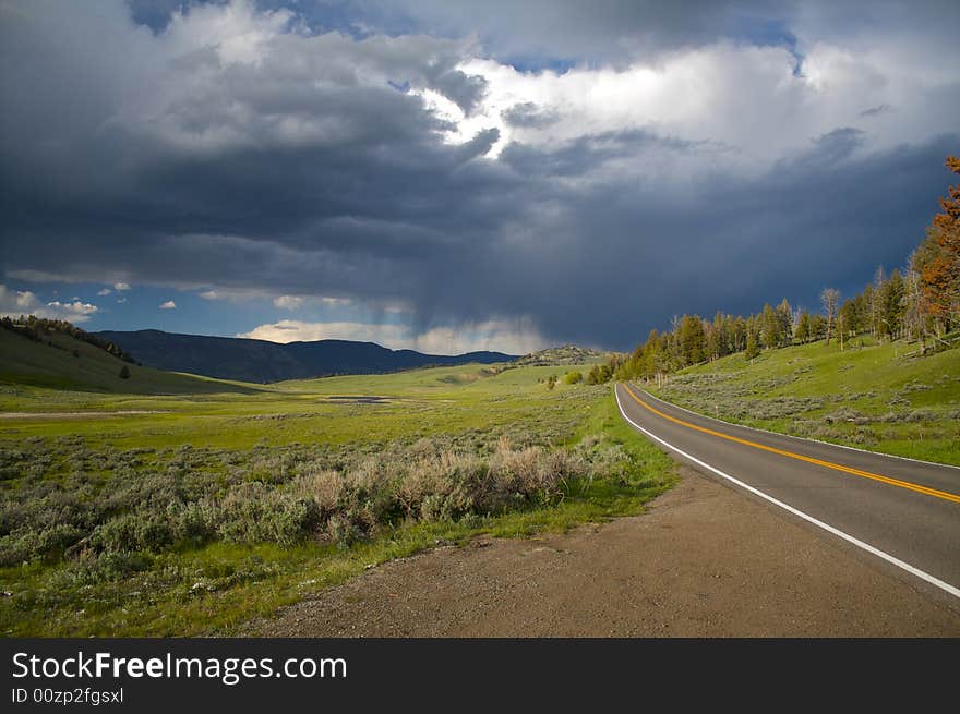 A lone road headed into a storm in Yellowstone. A lone road headed into a storm in Yellowstone