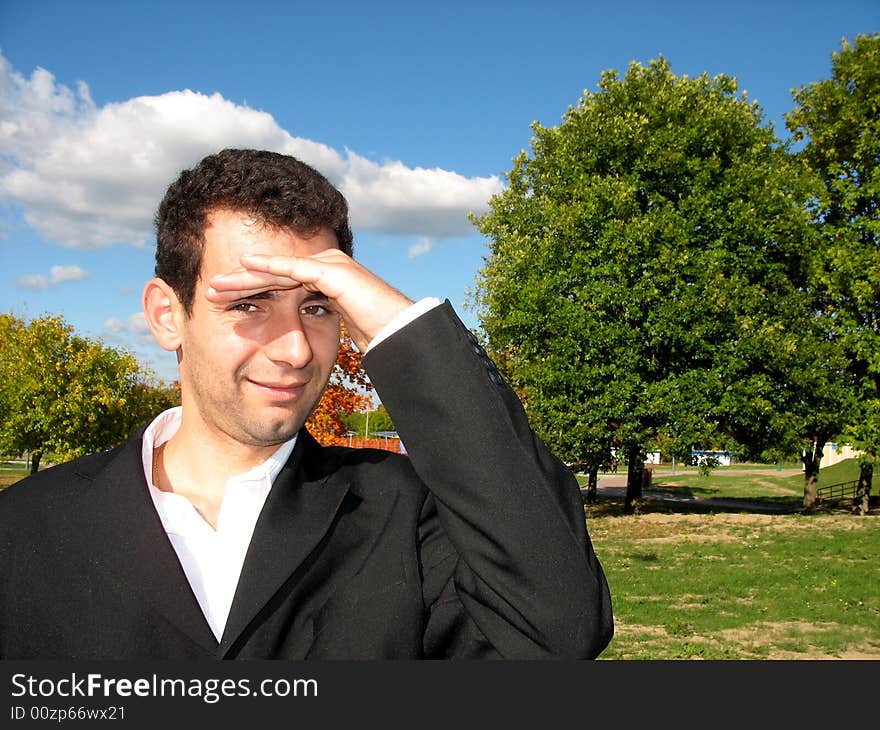 The young man is walking through the park. The young man is walking through the park