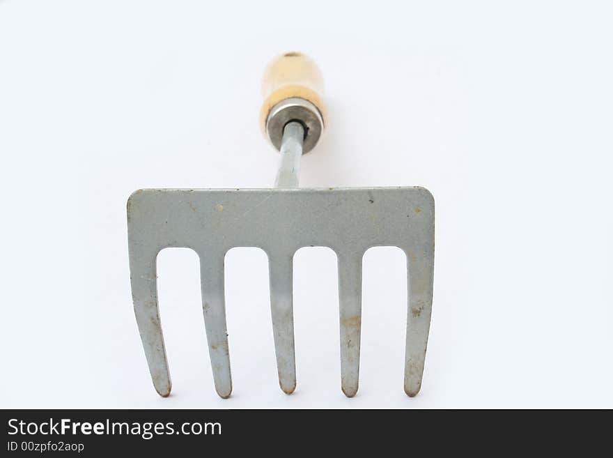 Hand rake on white background with shallow depth of field